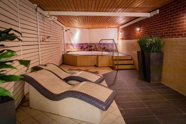 En bubbelpool och två vilosängar med dämpad belysning